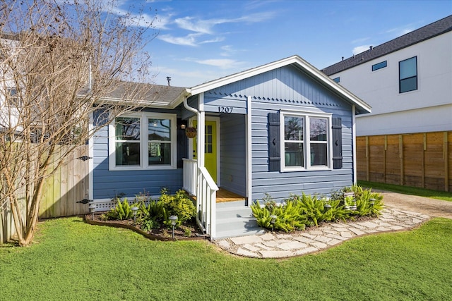 view of front of home featuring a front lawn and fence