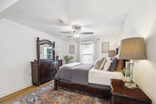 bedroom with visible vents, baseboards, light wood-style floors, and a ceiling fan