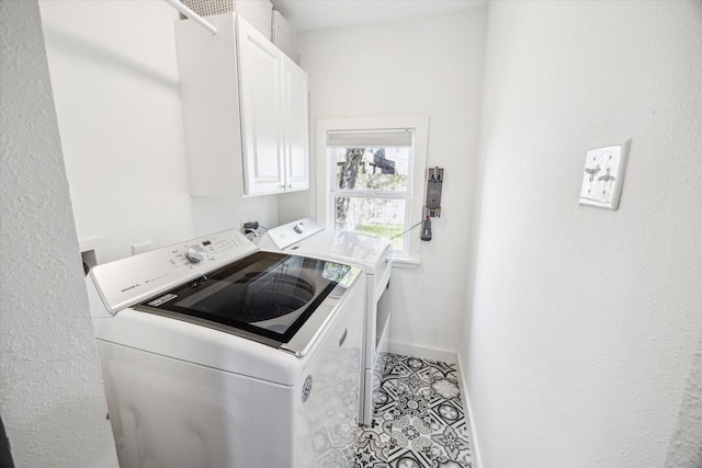 washroom with light tile patterned floors, baseboards, cabinet space, and washing machine and clothes dryer