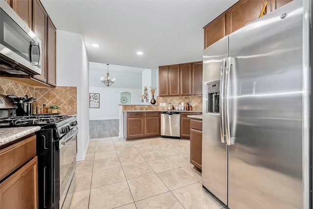 kitchen featuring light tile patterned floors, tasteful backsplash, a chandelier, and stainless steel appliances