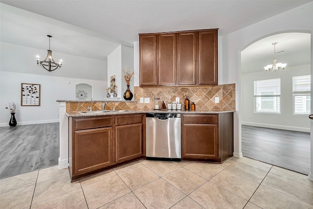 kitchen with a sink, a notable chandelier, stainless steel dishwasher, and light tile patterned flooring