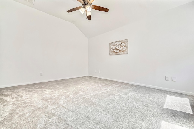 empty room with vaulted ceiling, carpet flooring, a ceiling fan, and baseboards