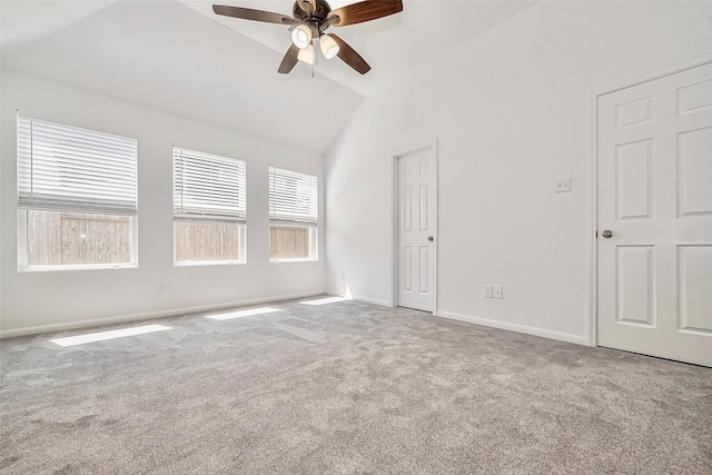 carpeted spare room with vaulted ceiling, baseboards, and ceiling fan