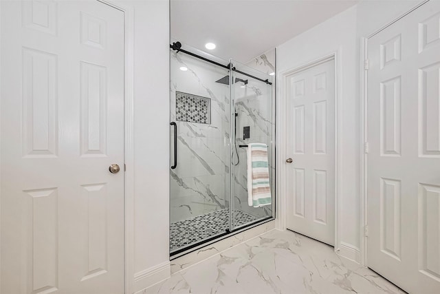 full bathroom featuring baseboards, marble finish floor, and a marble finish shower