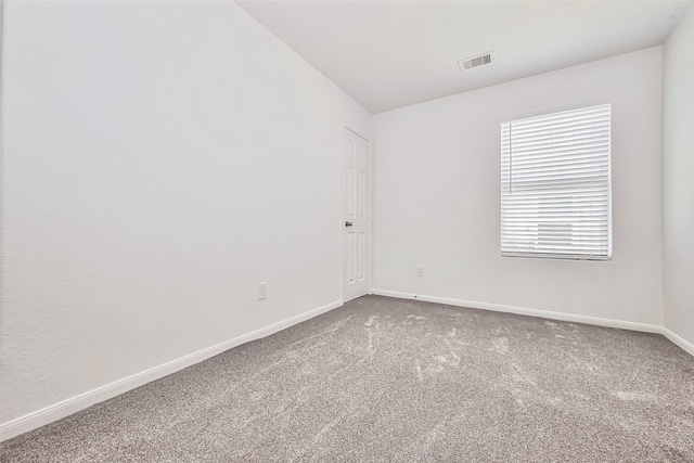 empty room with visible vents, baseboards, and carpet floors