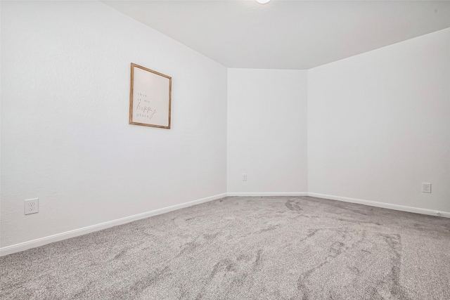 empty room with baseboards and carpet