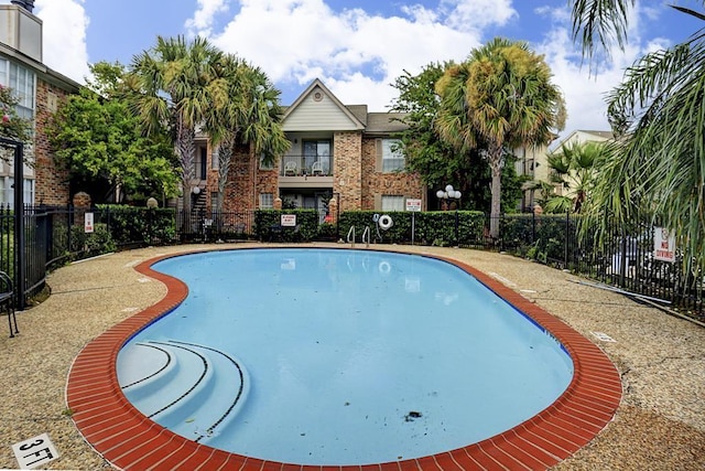 view of swimming pool featuring fence