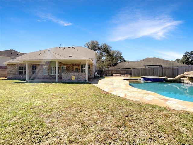 view of swimming pool with a fenced backyard, a patio, a pool with connected hot tub, and a yard