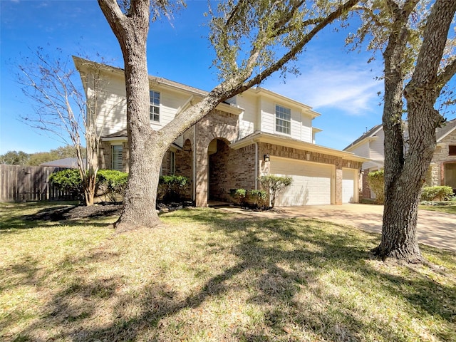 traditional-style home with concrete driveway, fence, a garage, and a front yard