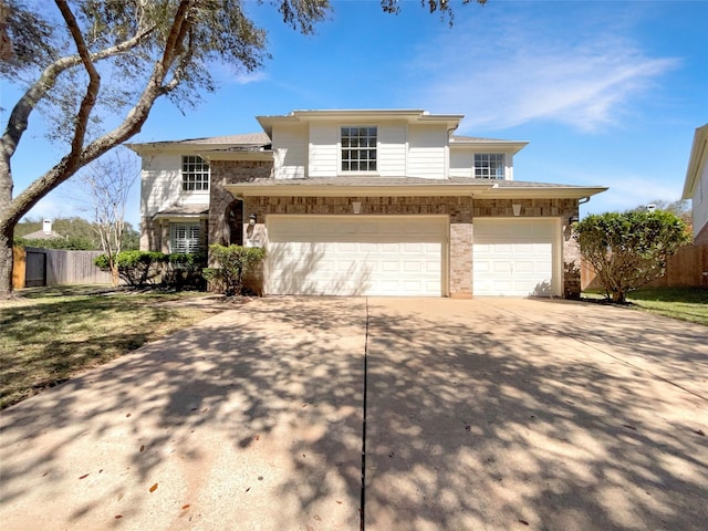 view of front of house featuring driveway, an attached garage, and fence