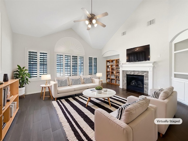 living area with visible vents, built in shelves, dark wood finished floors, and a ceiling fan