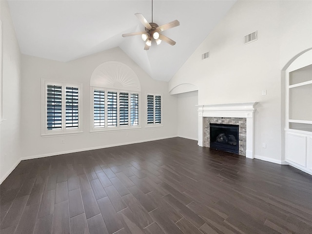 unfurnished living room with visible vents, built in shelves, dark wood-style floors, a fireplace, and ceiling fan