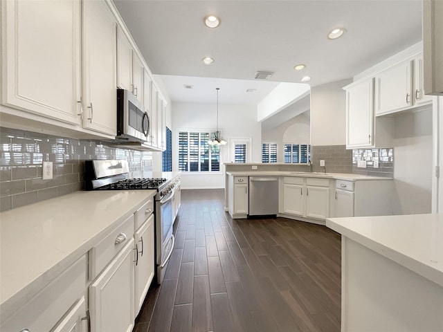 kitchen with white cabinets, dark wood-style floors, visible vents, and stainless steel appliances