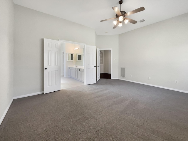 unfurnished bedroom featuring visible vents, baseboards, light carpet, and ensuite bathroom