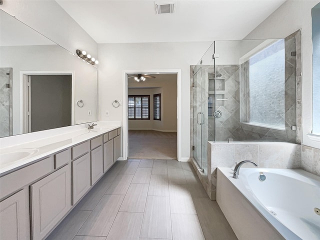 bathroom featuring visible vents, a garden tub, double vanity, a stall shower, and a sink