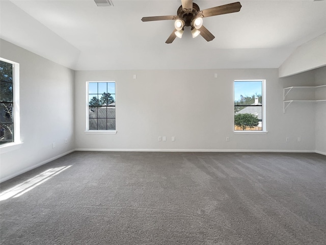 spare room featuring a wealth of natural light, ceiling fan, carpet, and vaulted ceiling