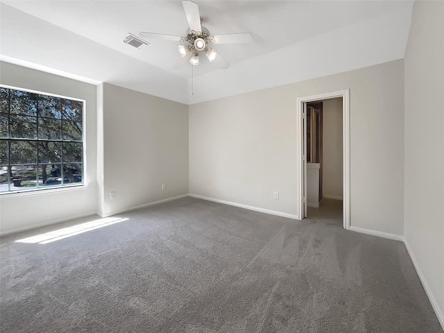 carpeted spare room with visible vents, baseboards, and a ceiling fan