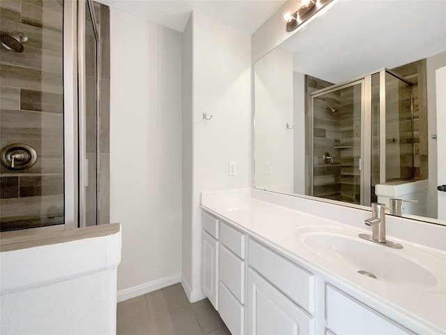 bathroom featuring baseboards, vanity, a shower stall, and tile patterned flooring