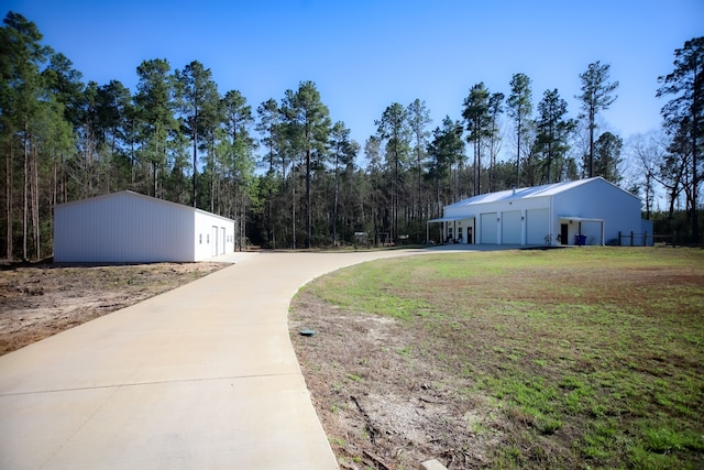 view of yard featuring an outbuilding, driveway, and a garage