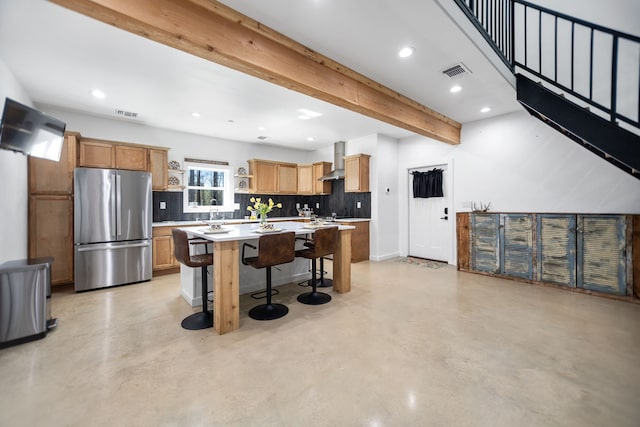 kitchen featuring light countertops, beam ceiling, freestanding refrigerator, wall chimney exhaust hood, and open shelves