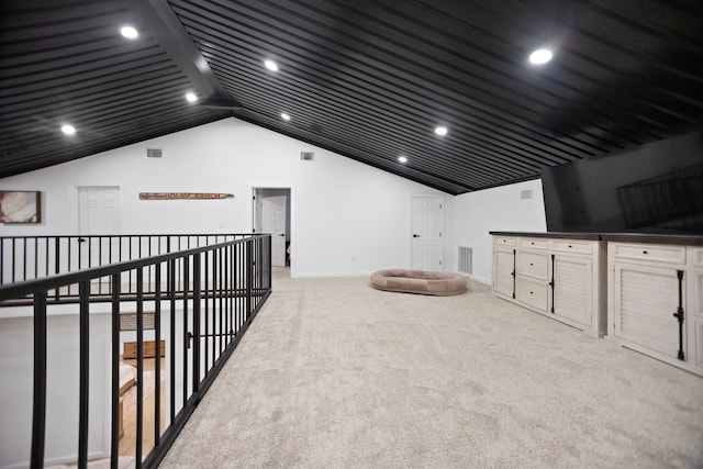 interior space with visible vents, light colored carpet, baseboards, and lofted ceiling