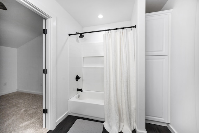 full bath featuring shower / bath combo with shower curtain, baseboards, and wood finished floors