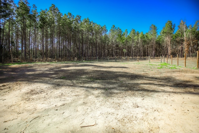 view of yard featuring fence and a view of trees