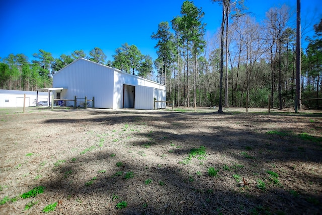 view of yard featuring a detached garage and an outbuilding