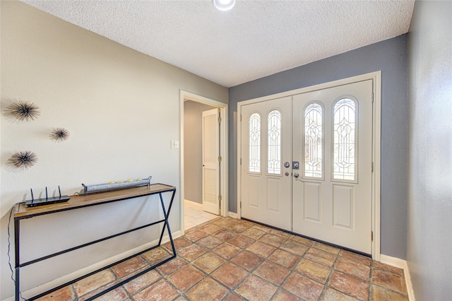 entryway with baseboards and a textured ceiling