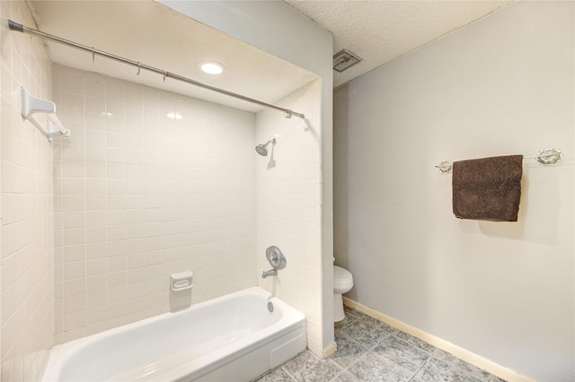 full bathroom featuring baseboards, toilet,  shower combination, and a textured ceiling