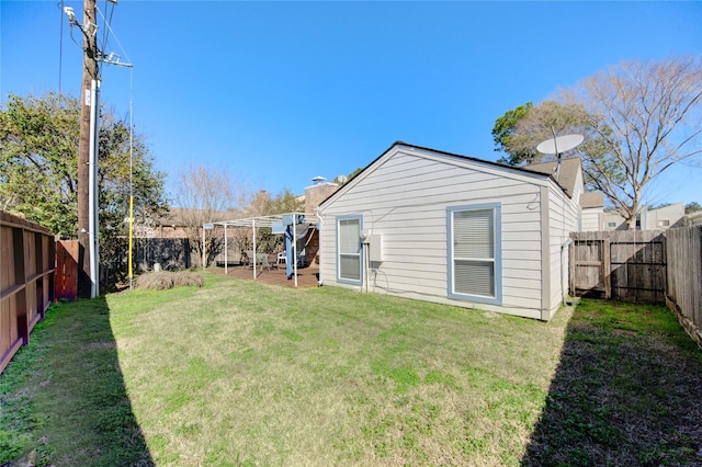 rear view of property featuring a lawn and a fenced backyard