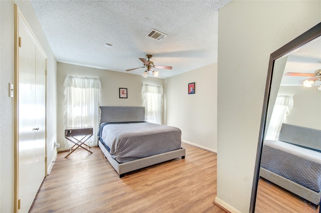 bedroom with visible vents, baseboards, light wood-style flooring, and a ceiling fan