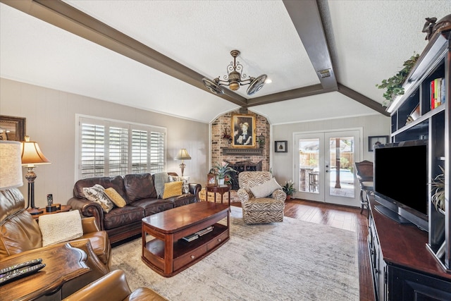 living room with visible vents, hardwood / wood-style flooring, a textured ceiling, lofted ceiling, and a chandelier