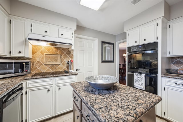 kitchen featuring visible vents, under cabinet range hood, decorative backsplash, white cabinets, and black appliances