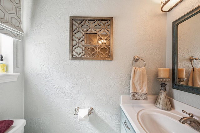 bathroom with vanity and a textured wall