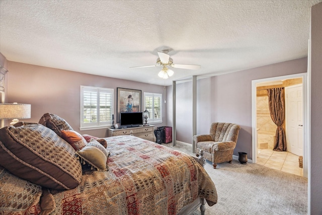 carpeted bedroom featuring a textured ceiling, connected bathroom, baseboards, and ceiling fan