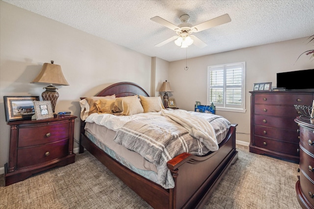 bedroom featuring baseboards, ceiling fan, a textured ceiling, and carpet