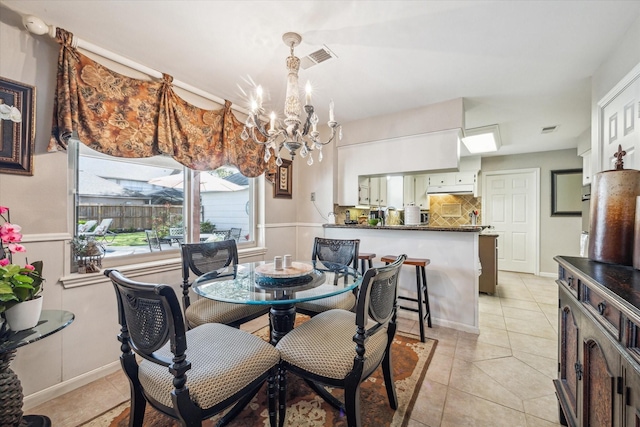 dining area featuring a notable chandelier, light tile patterned flooring, and visible vents