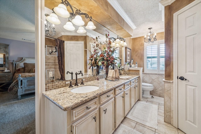 bathroom with a notable chandelier, a textured ceiling, tile walls, and a sink