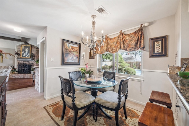 dining area with light tile patterned flooring, baseboards, visible vents, and a chandelier