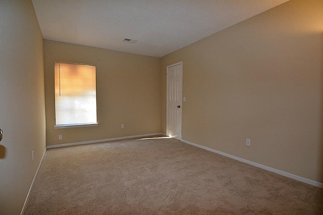 empty room with visible vents, baseboards, and carpet floors