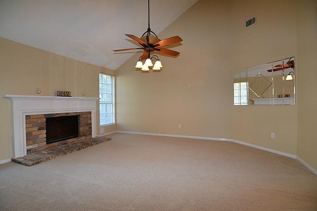 unfurnished living room featuring a healthy amount of sunlight, a fireplace with raised hearth, carpet, and ceiling fan