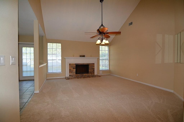 unfurnished living room featuring carpet floors, high vaulted ceiling, a healthy amount of sunlight, and a fireplace with raised hearth