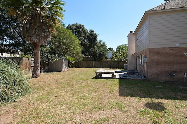 view of yard featuring an outbuilding, a shed, a patio, and a fenced backyard