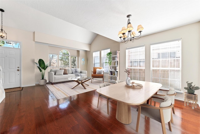 dining space with a chandelier, baseboards, lofted ceiling, and wood finished floors