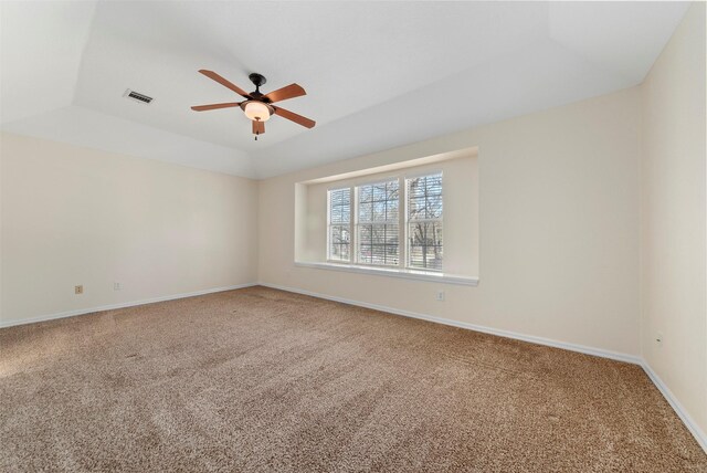 carpeted spare room featuring visible vents, baseboards, and a ceiling fan