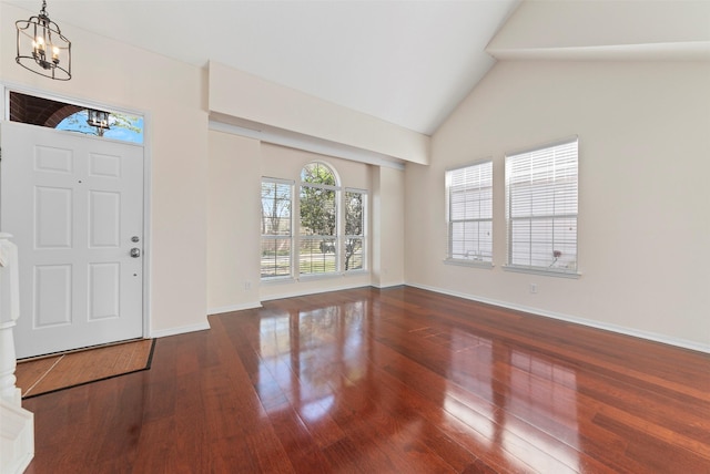 entrance foyer featuring a chandelier, high vaulted ceiling, baseboards, and wood finished floors