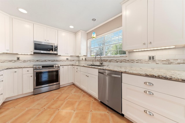 kitchen featuring a sink, backsplash, appliances with stainless steel finishes, and white cabinets