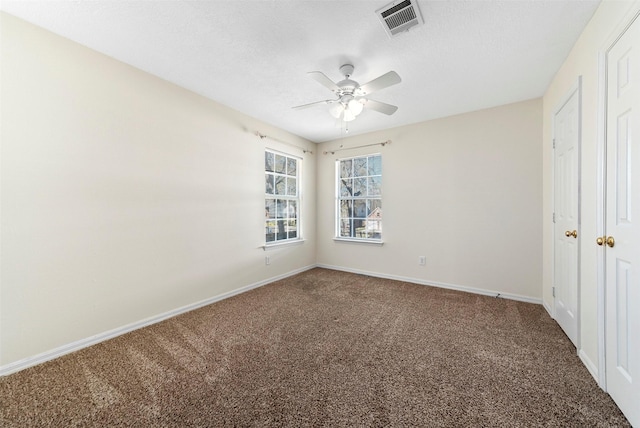 unfurnished bedroom with visible vents, a ceiling fan, a textured ceiling, carpet flooring, and baseboards