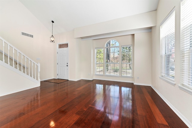 foyer featuring hardwood / wood-style floors, stairs, a healthy amount of sunlight, and visible vents